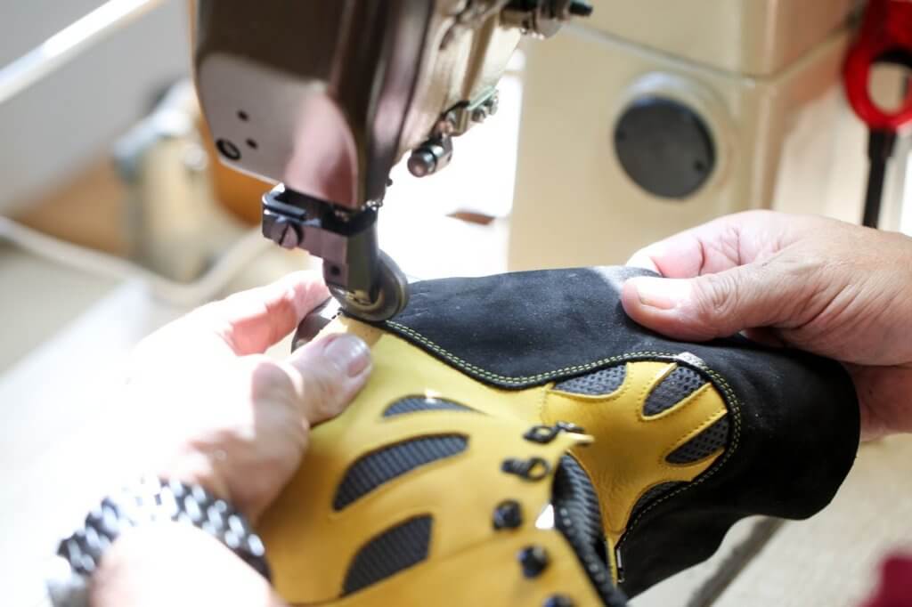 Podo-orthésiste en train de réaliser une couture sur une chaussure de travail